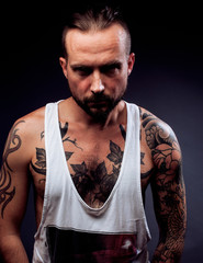 A man with tattooes on his arms. Silhouette of muscular body. ca