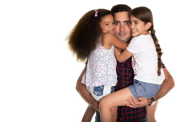 Multiracial family, Hispanic father with a funny expression hugging his mixed race daughters