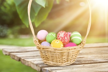 Poster - Easter basket filled with colorful eggs on a white background