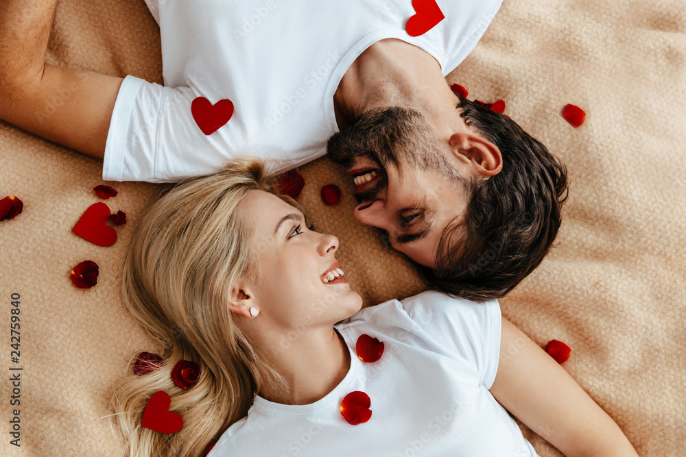 Couple. Love. Valentine's day. Emotions. Man and woman are looking at each other and smiling; top view - obrazy, fototapety, plakaty 