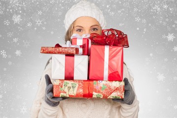 Smiling woman with many gift boxes on background