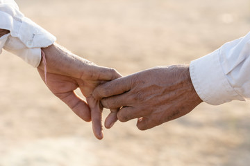 Couple hands on the street during Pushkar Camel Mela. Pushkar, Rajasthan, India, close up. In India, it is normal to go to men holding each other by the hand