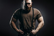 Lumberjack brutal red beard muscled man in brown shirt with smoking tube standing on dark background