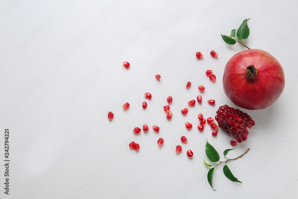 Ripe pomegranate with seeds on white background