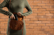 © Pixel-Shot - Young woman with gun on brick background