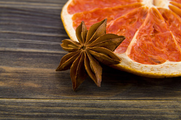 Wall Mural - dried grapefruit and anise stars on wooden background