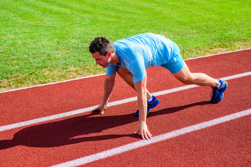 Adult runner prepare race at stadium. How to start running. Sport tips from professional runner. Man athlete runner stand low start position stadium path. Make effort for victory. Runner ready to go