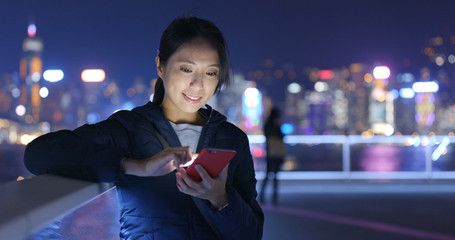 Wall Mural - Asian woman use of mobile phone in Hong Kong at night