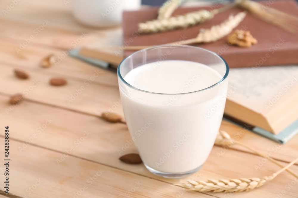 Glass of fresh milk on wooden table