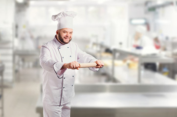 Wall Mural - Funny cheerful chef in white uniform on a background.