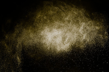 Wall Mural - golden powder color spreading effect for makeup artist or graphic design in black background