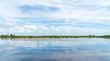 View across water, wetlands with mirror reflection of sky and clouds