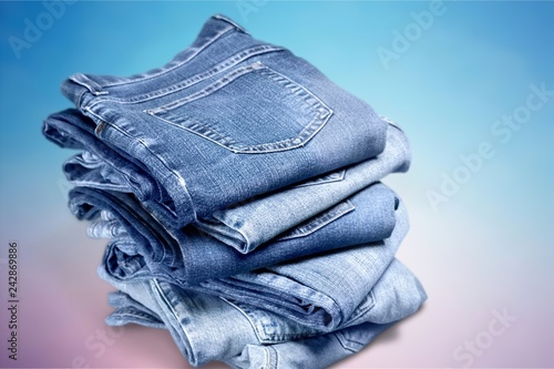 Fotografia Pile of blue jeans over white background
