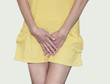 © Todayphoto - Young woman in a yellow short dress standing with her hands between legs, needs a restroom, isolated for white background. Women's health, gynecology.