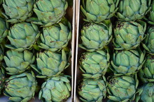 Crate Of Green And Purple Artichokes At A Farmers Market 