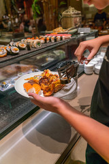 Wall Mural - Vertical photo of customer choosing foods in the hotel buffet