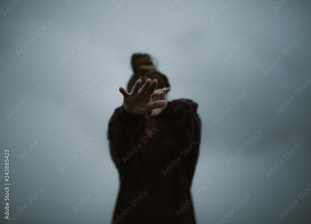 woman's hands in the clouds moody and dark - obrazy, fototapety, plakaty 