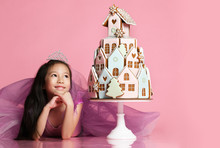 Little Asian Girl In Crown And Purple Dress With Ginger Cookie Cake For Birthday Party Celebration