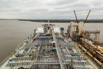 Oil product tanker discharging to jetty in port of Baton Rouge.