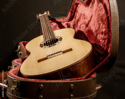 Fotografie, Obraz Acoutic guitar sits in red velvet lined case