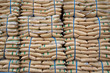 Many brown plastic white sacks with goods are in big warehouse for distribution to customer, import export logistics business.