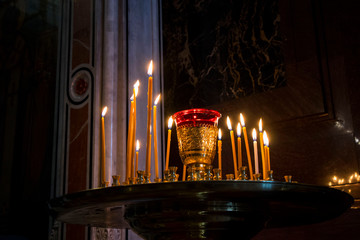 Wall Mural - Many burning wax candles in the orthodox church or temple