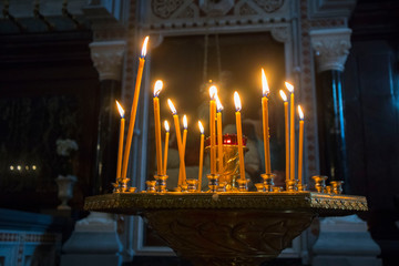 Wall Mural - Many burning wax candles in the orthodox church or temple