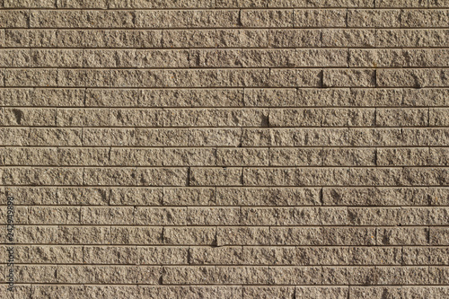 Fotografía Rough textured tan brown stone brick wall abstract background