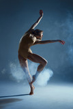 Dancing in cloud concept. Muscle brunette beauty female girl adult woman dancer athlete in fog smoke fume wearing dance bodysuit making emotional dance element performance on isolated grey background