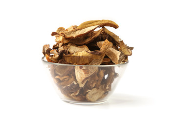 Dried mushrooms in glass bowl isolated on white background. Wild edible dried boletus mushrooms.