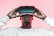 © Damir Khabirov - Portrait of African guy isolated on pink background wearing headset of virtual reality