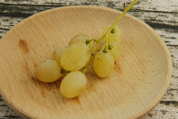 Poster - Raisins blancs sur une assiette en bois