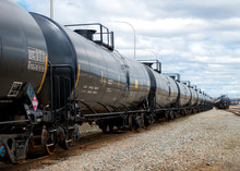 Black Railway Tanker Cars Of The Type Used To Transport Petroleum Products. Several Cars Visible On Two Separate Sets Of Tracks. Identification Markings Have Been Removed, Only Technical Info Remains.