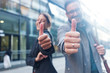 Businessman and businesswoman showing thumb up