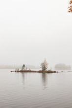 Small Island In A Lake In Fog During Autumn. Shot In Sweden An Early Morning All Alone In The Forest. 
