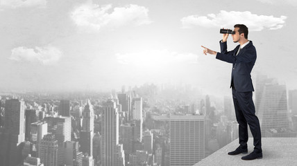 Wall Mural - businessman looking forward to a city with binoculars from skyscraper concept