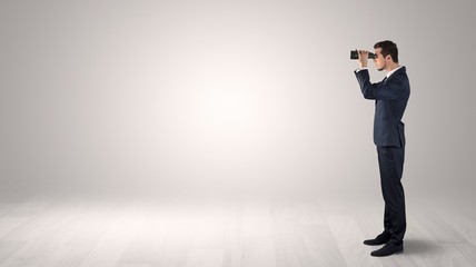 Wall Mural - businessman looking forward with binoculars in an empty space