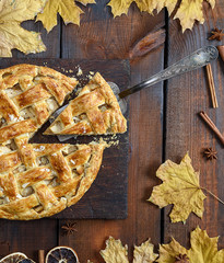 round apple pie on a brown wooden board