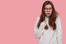 Do You Blame Me? Dissatisfied Female Model With Indignant Facial Expression, Asks Question And Points At Herself, Dressed In White Casual Oversized Sweater, Isolated Over Pink Wall With Free Space