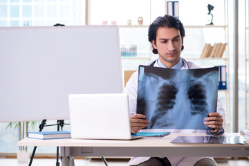 Young handsome male radiologist in front of whiteboard 