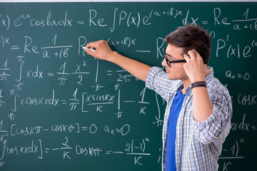 Young male student studying math at school