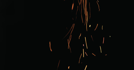 Wall Mural - hot sparks from charcoal moving up on black background