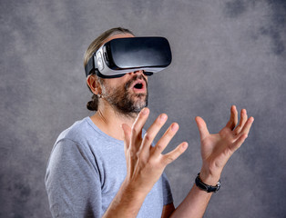 man with virtual reality glasses pointing looking surprised