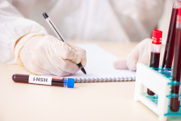 Poster - Young handsome lab assistant testing blood samples in hospital 