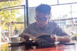© Quang - Man reading favourite book at cafe in the summer day