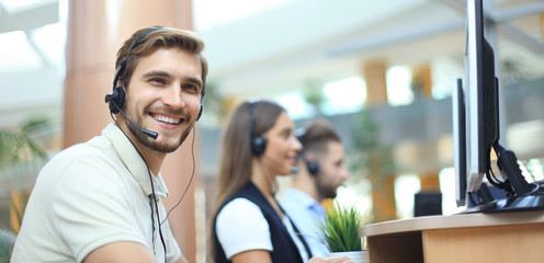 Wall Mural - Attractive positive young businesspeople and colleagues in a call center office.