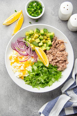 Canvas Print - Salad with tuna, avocado, onion, egg and lemon. Spring healthy delicious lunch on light background