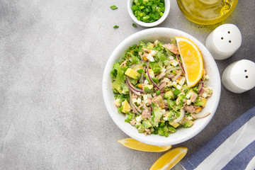 Wall Mural - Salad with tuna, avocado, onion, egg and lemon. Spring healthy delicious lunch on light background