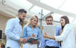 © ty - Business discussion. Modern people in casual wear having a brainstorm meeting while standing in the creative office.