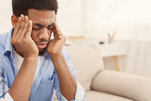 Fotomural African-american man suffering from headache at home